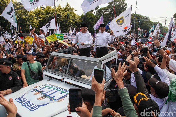 Anies Baswedan dan Muhaimin Iskandar (Cak Imin) naik Land Rover atap terbuka konvoi pendaftaran capres-cawapres di KPU, Jakarta. Mereka menyapa pendukungnya yang sudah menunggu.