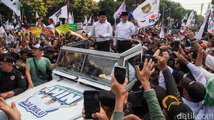 Anies Baswedan dan Muhaimin Iskandar (Cak Imin) naik Land Rover atap terbuka konvoi pendaftaran capres-cawapres di KPU, Jakarta. Mereka menyapa pendukungnya yang sudah menunggu.