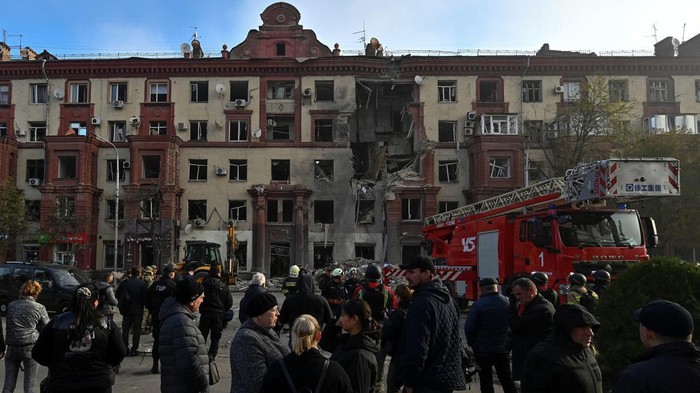Perang Rusia-Ukraina Masih Berkecamuk, Katedral-Permukiman Dirudal Local residents stand in front of a residential building damaged by a Russian missile strike, amid Russia's attack on Ukraine, in Zaporizhzhia, Ukraine October 18, 2023. REUTERS/Stringer