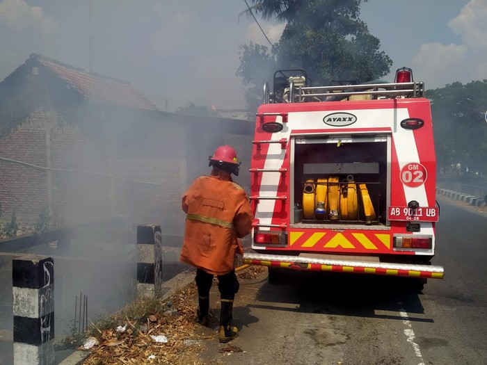 Petugas Damkarmat BPBD Bantul memadamkan api yang membakar rumpun bambu dan gubuk di pinggir Ring Road Selatan, Kalurahan Tirtonirmolo, Kasihan, Kabupaten Bantul, Kamis (19/10/2023) siang.