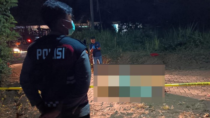 Petugas saat mengevakuasi jenazah Kusaini yang tewas dibunuh Samidi di Malang