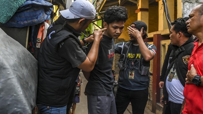 Petugas Kepolisian Polres Jakarta Utara mengamankan warga diduga pelaku pengedaran narkoba dan tawuran warga saat melakukan penggerebekan di Kelurahan Kalibaru, Cilincing, Jakarta, Kamis (19/10/2023). Dalam penggerebekan tersebut petugas berhasil mengamankan 15 terduga tersangka pelaku pengedaran narkoba dan tawuran warga dengan barang bukti berupa sajam dan narkoba jenis sabu serta alat hisap (bong). ANTARA FOTO/Muhammad Adimaja