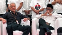 Ganjar tampak memakai kemeja hitam sementara Mahfud Md memakai kemeja putih. 
