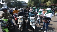 Sejumlah Kader PKB dari DPC maupun DPW kompak membagikan krudung dan kaos kepada pengguna di Jalan Wonokromo, saat pasangan Anies baswedan dan Muhaimin Iskandar daftar ke KPU.