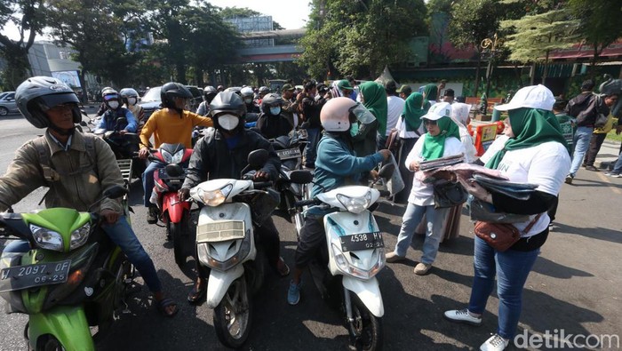 Relawan Amin Bagi krudung ke Pengguna Jalan Relawan Amin Bagi krudung ke Pengguna Jalan