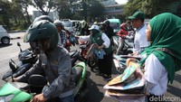 Para kader ini membagikan kaos di depan Kebun Binatang Surabaya (KBS). Dan pengguna jalan pun antusias mengantri.