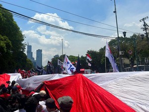 Relawan Ganjar-Mahfud Bentangkan Bendera Merah Putih di Jalan Menuju KPU