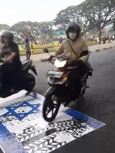 Stiker mirip Bendera Israel ditempel di aspal dekat Balai Kota Malang.