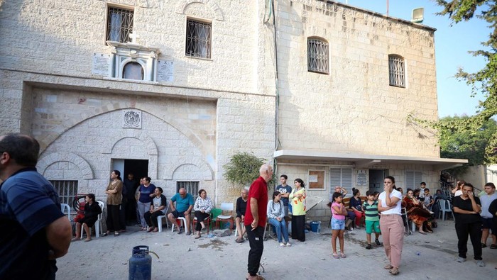 Women react at the Greek Orthodox Saint Porphyrius Church which was damaged by an Israeli strike, where Palestinians who fled their homes take shelter, in Gaza City, October 20, 2023. REUTERS/Mohammed Al-Masri