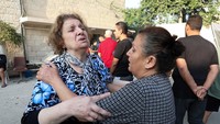 Wanita bereaksi di Gereja Ortodoks Yunani Saint Porphyrius yang dirusak oleh serangan Israel.  