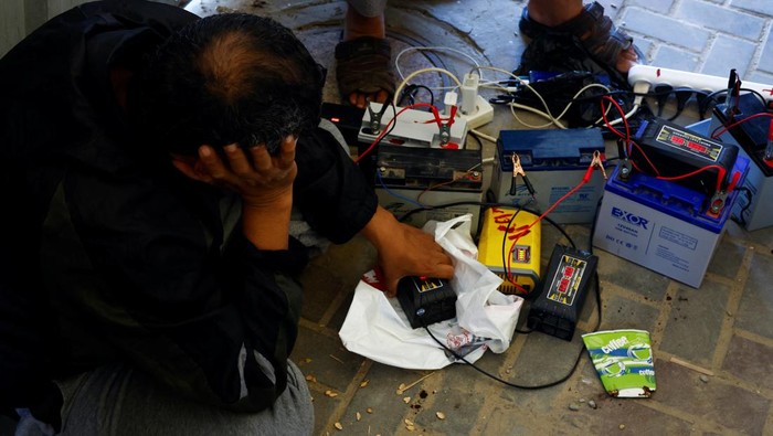 Listrik Diputus Israel, Warga Gaza Antre Charge HP Pakai Panel Surya Palestinians charge their mobile phones from a point powered by solar panels provided by Adel Shaheen, an owner of an electric appliances shop, as electricity remains cut during the ongoing Israeli-Palestinian conflict, in Khan Younis in the southern Gaza Strip October 19, 2023. REUTERS/Mohammed Salem