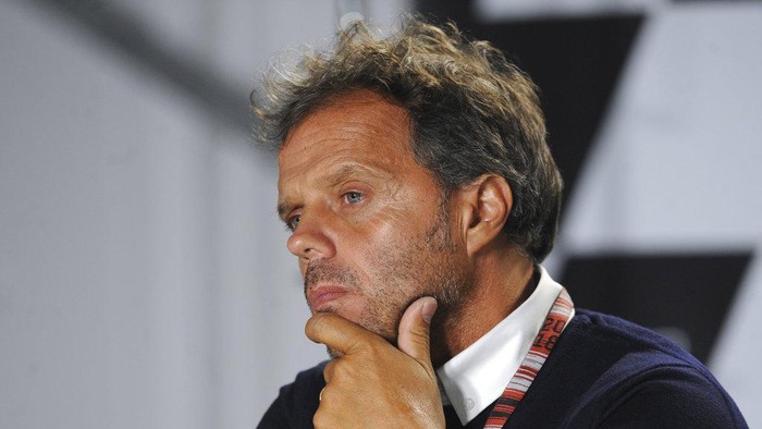 Dorna representative Loris Capirossi listens during a news conference to announce the decision to cancel the British Motorcycle Grand Prix due to track conditions following heavy rain at the Silverstone racetrack in Silverstone, England, Sunday, Aug. 26, 2018. (AP Photo/Rui Vieira)