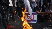 Massa Aksi Bela Palestina membakar bendera Israel dan foto PM Israel Benjamin Netanyahu dalam aksi di depan kantor Kedutaan Besar Amerika Serikat, Jakarta, Jumat (20/10/2023).  
