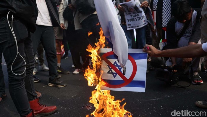 Melihat Massa Bakar Bendera dan Foto PM Israel Benjamin Netanyahu Dalam unjuk rasa di depan Kedubes AS di Jakarta, massa membakar bendera Israel dan foto PM Israel Benjamin Netanyahu. Aksi ini sebagai bentuk dukungan pada Palestina.