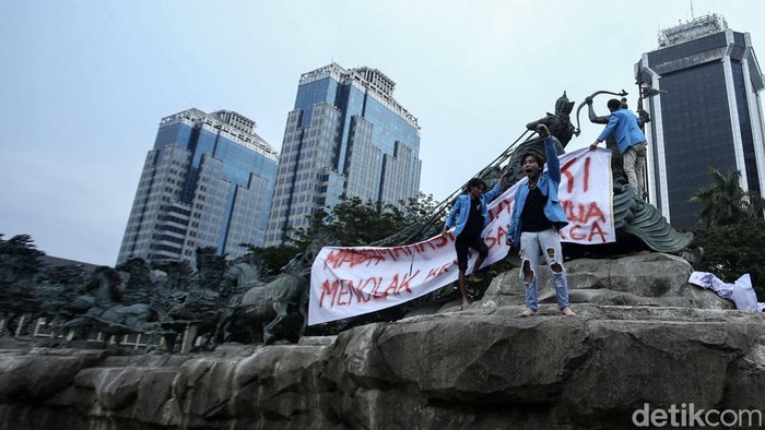 Mahasiswa yang tergabung dalam BEM Seluruh Indonesia demo di kawasan Patung Kuda, Jakarta Pusat, Jumat (20/10/2023). Selain berorasi, mereka juga memasang spanduk protes di atas Patung Kuda.
