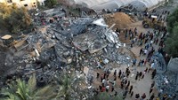 Warga berkumpul di lokasi kerusakan akibat serangan Israel. Mereka berusaha mencari korban di antara puing juga harta benda yang masih bisa diselamatkan.