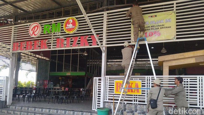 Petugas memasang peringatan di RM Bebek Rizky Bangkalan yang tak taat membayar pajak