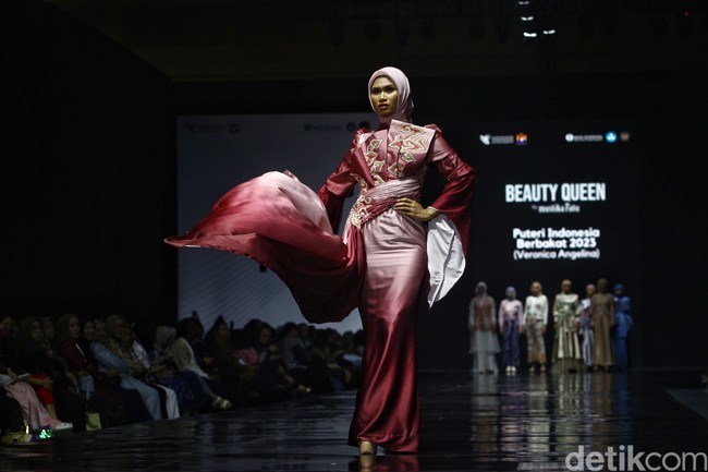 Pemegang gelar Puteri Indonesia Berbakat 2023 Veronica Angelina melenggang di catwalk dengan memakai hijab saat memeragakan dress merah dari BT Batik Trusmi x Hijaberlin. Foto: Ari Saputra