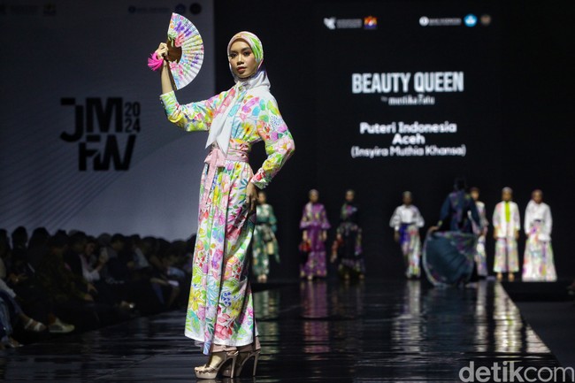 Penampilan Puteri Indonesia selanjutnya dalam fashion show Project Sekar x Long Story Short di JMFW 2024 adalah perwakilan Aceh, 𝐈𝐧𝐬𝐲𝐢𝐫𝐚 𝐌𝐮𝐭𝐡𝐢𝐚 𝐊𝐡𝐚𝐧𝐬𝐚. Puteri Indonesia Aceh itu tampil dengan dress dan hijab motif bunga warna-warni. Foto: Ari Saputra