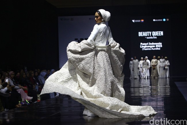 Puteri Indonesia Lingkungan 2023 Yasinta Aurellia tampil sebagai model memakai turban dan gaun putih koleksi Rose & Beyond dari desainer Ayu Dyah Andari di Jakarta Muslim Fashion Week 2024. Foto: Ari Saputra