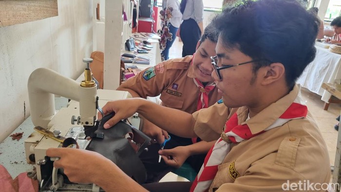 Sejumlah siswa SMKN 12 Surabaya memanfaatkan limbah sepatu kulit menjadi merchandise.