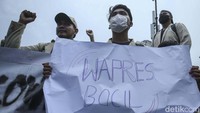 Massa membawa spanduk bertuliskan wapres bocil. 