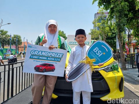 Adit dan ibunya berfoto di mobil kuning yang sekarang menjadi miliknya