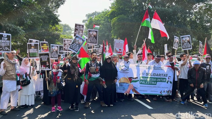 Peserta aksi solidaritas mendukung Palestina membawa anak saat turun ke jalan