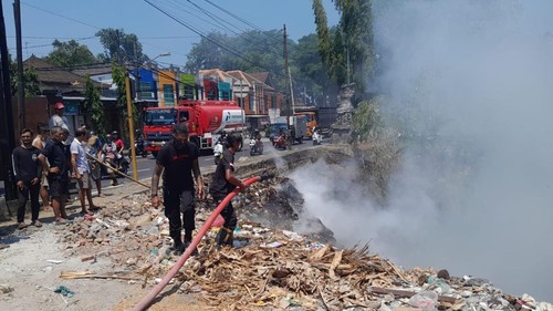 Petugas pemadam kebakaran berusaha memadamkan api yang membakar tumpukan sampah di sebelah timur Pospol, Banjar Dakdakan, Desa Abiantuwung, Kecamatan Kediri, pada Sabtu (21/10/2023) siang. (Polsek Kediri)