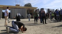 Tampak seorang pria sujud syukur setelah gerbang Rafah dibuka untuk truk bantuan masuk. (AP Photo/Mohammed Asad)