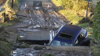 Sebuah mobil terperosok ke dalam jembatan yang putus akibat longsor di Dundee, Skotlandia, Sabtu, 21 Oktober 2023. Andrew Milligan/PA via AP. 