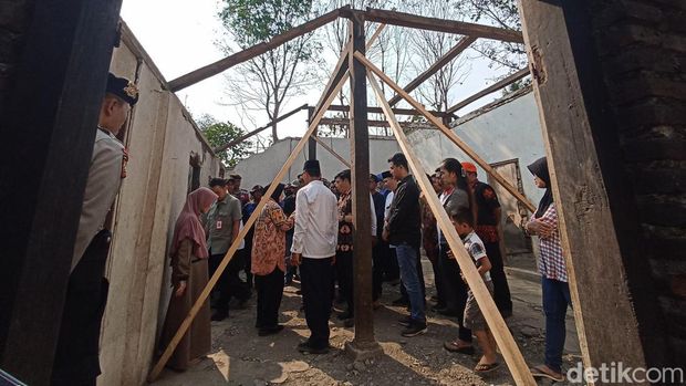 Mentri Sosial (Mensos) Tri Rismaharini datang ke rumah Sasmiati yang sedang diperbaiki. Sasmiati dan 3 anaknya merupakan keluarga difabel.