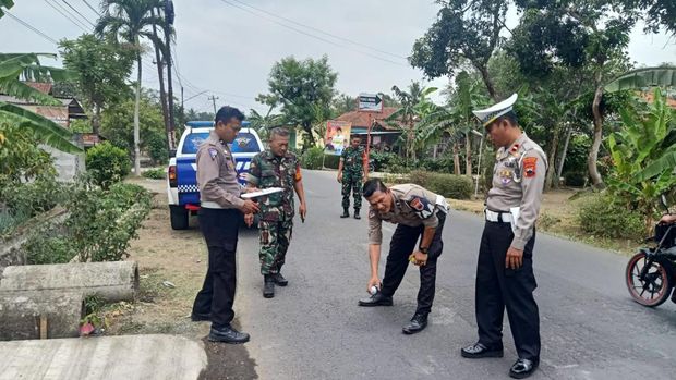 Petugas kepolisian melakukan olah TKP di lokasi mobil pickup terguling dan menyebabkan 1 penumpang meninggal dunia di Desa/Kecamatan Kedungreja, Kabupaten Cilacap, Minggu (22/10/2023).