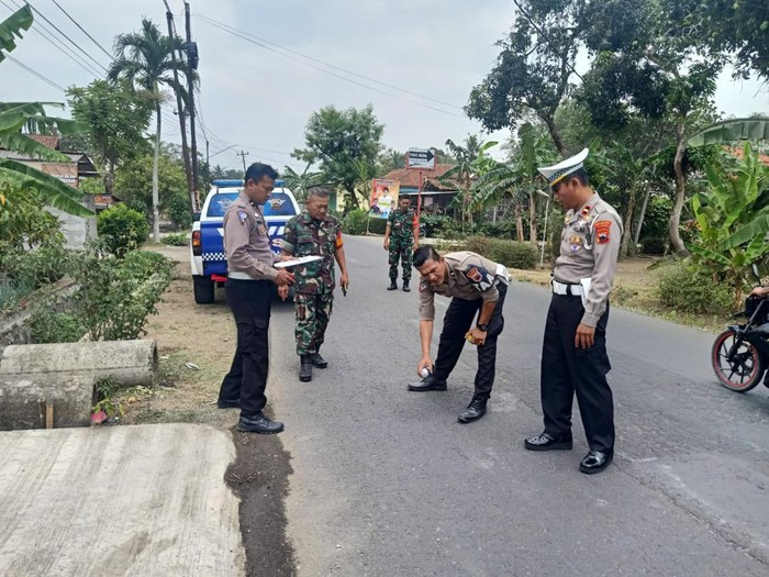 Petugas kepolisian melakukan olah TKP di lokasi mobil pickup terguling dan menyebabkan 1 penumpang meninggal dunia di Desa/Kecamatan Kedungreja, Kabupaten Cilacap, Minggu (22/10/2023).