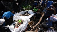 Tampak sejumlah relawan yang terdiri dari pria dan wanita turun ke kolong rumah warga dengan mengenakan sepatu boots. Mereka bahu membahu mengambil sampah yang berada di kolong rumah warga. Foto: Sahrul Alim
