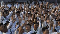 Sejumlah santri melambaikan tangan ketika mengikuti apel Hari Santri Nasional di Tugu Pahlawan, Surabaya, Jawa Timur, Minggu (22/10/2023). 