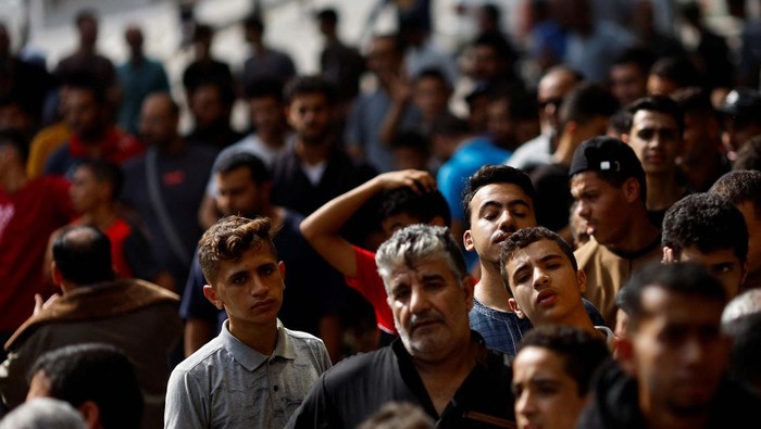 Potret Warga Gaza Antre Beli Roti Palestinians queue as they wait to buy bread from a bakery, amid shortages of food supplies and fuel, as the conflict between Israel and Palestinian Islamist group Hamas continues, in Khan Younis in the southern Gaza Strip October 22, 2023. REUTERS/Mohammed Salem