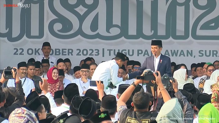 Presiden Jokowi bersama santri yang mendapat hadiah sepeda.