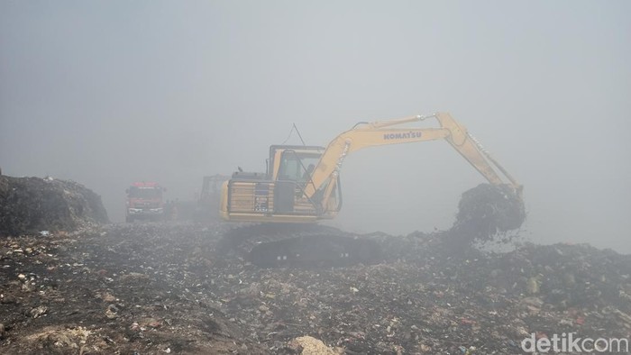 Proses pembuatan kolam yang akan diisi air pada bukit sampah di TPA Mandung, Tabanan, Minggu (22/10/2023). (chairul amri simabur/detikBali)