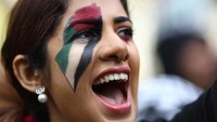 Seorang demonstran mengecat wajahnya dengan warna bendera Palestina. 