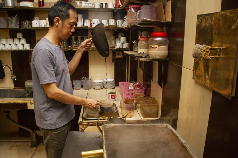 Pengunjung berbincang sambil menikmati minuman kopi di Warung Kopi (Warkop) Phoenam, Makassar, Sulawesi Selatan, Jumat (6/10/2023). Warkop legendaris tersebut didirikan pada 1946 oleh Liong Thay Hiong bersama kerabat dekatnya dan saat ini dikelola oleh generasi ketiga dengan tetap mempertahankan gaya penyajian secara tradisional. ANTARA FOTO/Arnas Padda/tom.