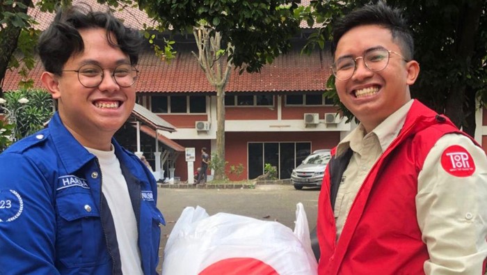 Alwin (vest merah) mengantarkan pesanan klien.