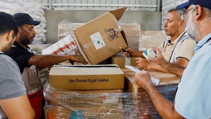 Red Crescent workers sort aid before being distributed to Palestinians, as the conflict between Israel and Palestinian Islamist group Hamas continues, in Khan Younis in the southern Gaza Strip, October 23, 2023. REUTERS/Ibraheem Abu Mustafa