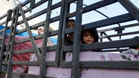 Anak-anak tidur di truk milik PBB yang parkir di halaman sekolah.  