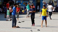 Anak-anak tampak bermain sepakbola saat tidak bisa lagi bersekolah.  