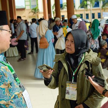 Julika Hasanah (jilbab hitam) sedang mewawancarai narasumber di Asrama Haji Medan. Julika kembali bekerja setelah 11 tahun jadi IRT usai suami meninggal dunia. (Foto: Dok. Pribadi Julika)
