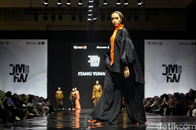 Fashion show koleksi ready to wear Itang Yunasz yang didesain putrinya Najla Kamila, di gelaran Jakarta Muslim Fashion Week 2024, ICE BSD, Tangerang. Koleksi ini menghadirkan modest wear nuansa cokelat dan oranye. Foto: Ari Saputra