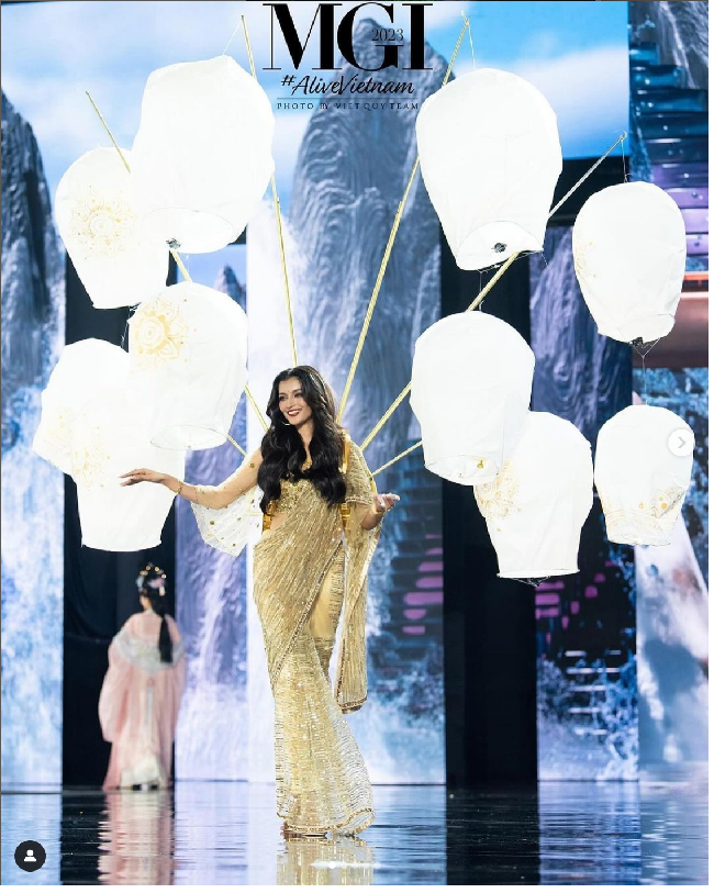 Miss Grand India Arshina Sumbul mengenakan kostum nasional bertemakan ‘Divali Festival.’ Tampak depan kostum Arshina terlihat sederhana yaitu busana khas India yaitu sari berwarna emas. Namun pada bagian belakangnya tampak heboh karena Arshina membawa beberapa lampion yang biasa ada di Festival Divali di India. Foto: Dok. Facebook/Miss grand International