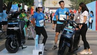 Peserta Jakarta Marathon 2023 antusias mendengarkan penjelasan mengenai motor listrik Electrum terbaru, hasil karya anak bangsa tim lokal Electrum, di Jakarta (22/10). Motor listrik yang didesain oleh Electrum sendiri telah teruji dan dikembangkan dari masukan rekan mitra driver Gojek, didesain khusus untuk jalanan Indonesia.  