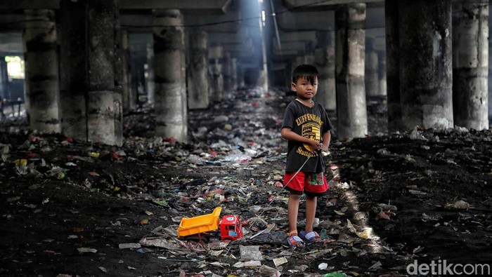 Seorang anak bermain di kawasan Kolong Tol Wiyoto Wiyono, Papanggo, Jakarta Utara, Selasa (25/1/2022). Saat ini masih banyak warga Jakarta yang tinggal di kolong tol dikarenakan faktor ekonomi sehingga tidak mampu untuk  tinggal di hunian yang layak di Ibu Kota.